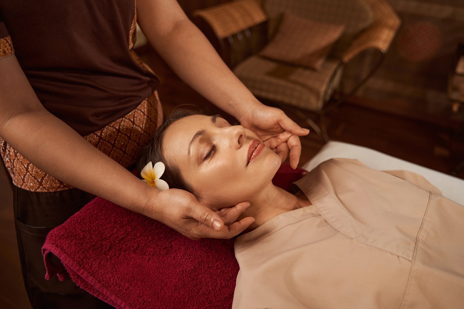 Experienced masseuse pressing reflex points on client neck using both hands